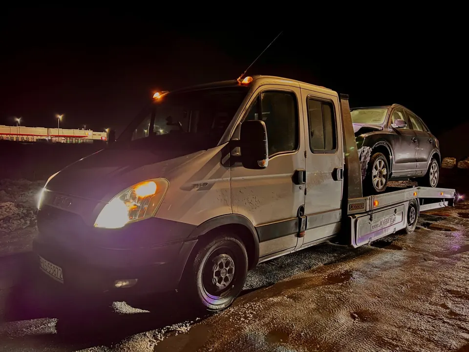 Transport samochodu na lawecie po zmroku